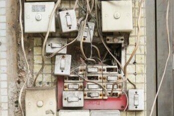 various unkept circuit boxes with tangled wiring