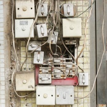 various unkept circuit boxes with tangled wiring