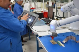 employee using a touchscreen operating a robotic arm