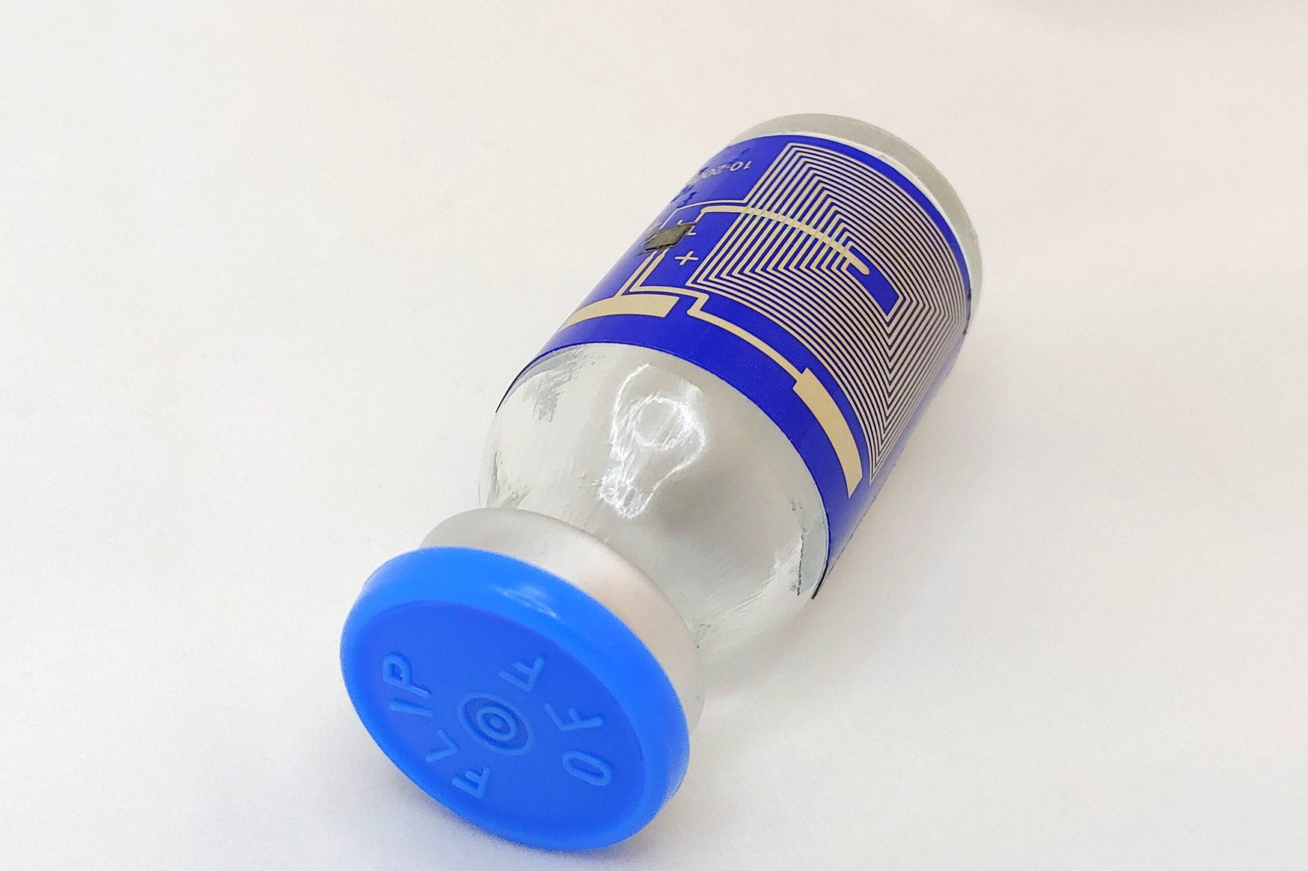 small sealed bottle wrapped with a printed circuit