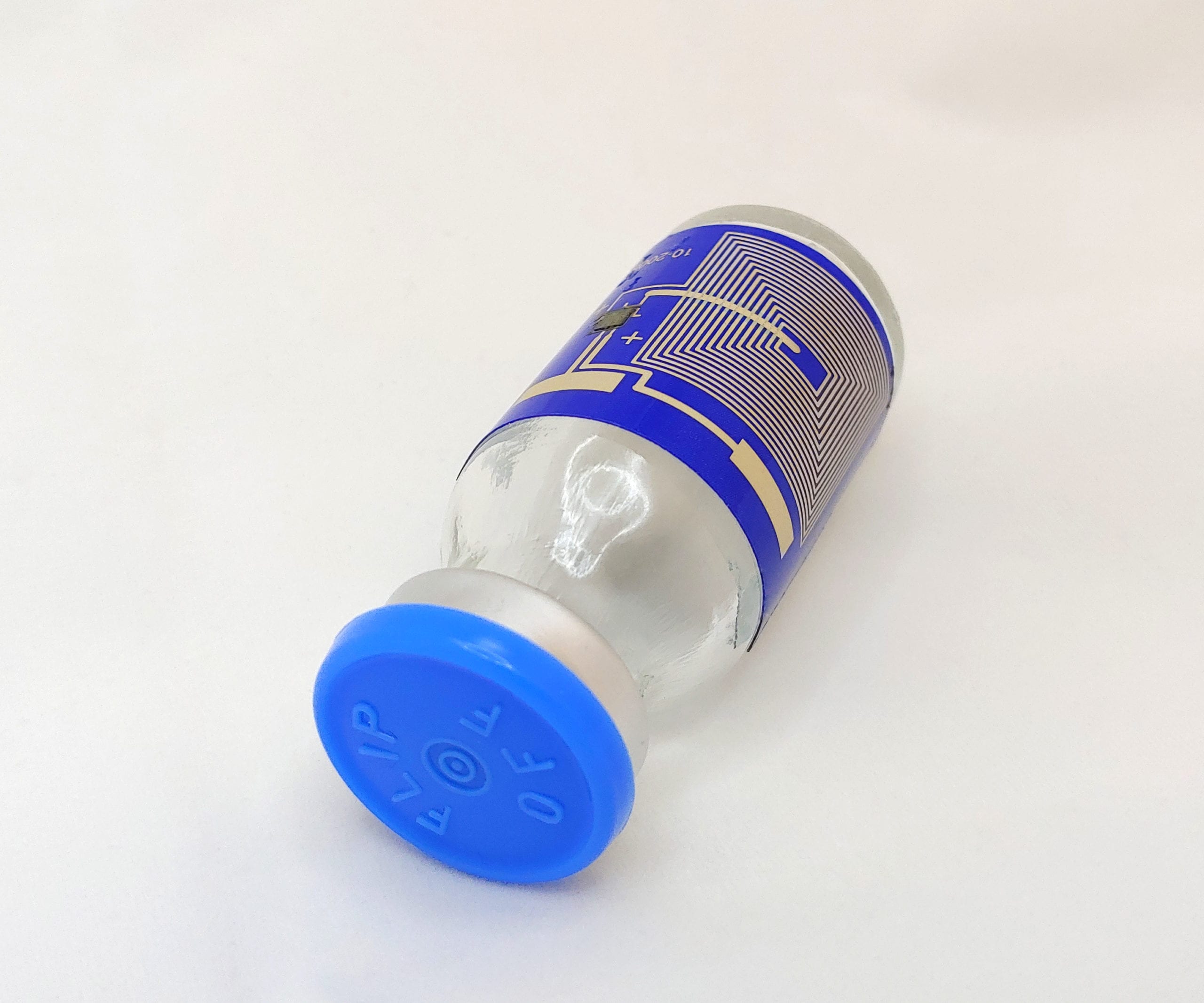 small sealed bottle wrapped with a printed circuit