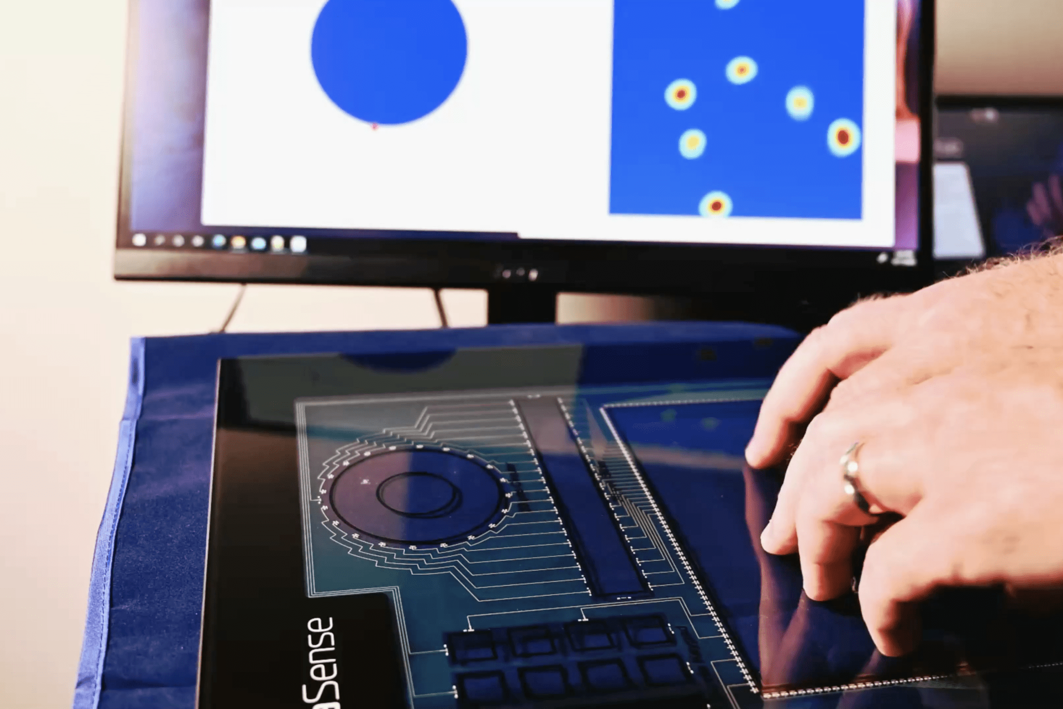 two hands that using a touchscreen system branded with SigmaSense logo