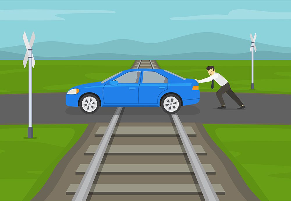 cartoon image of a person pushing a blue car across a railroad track