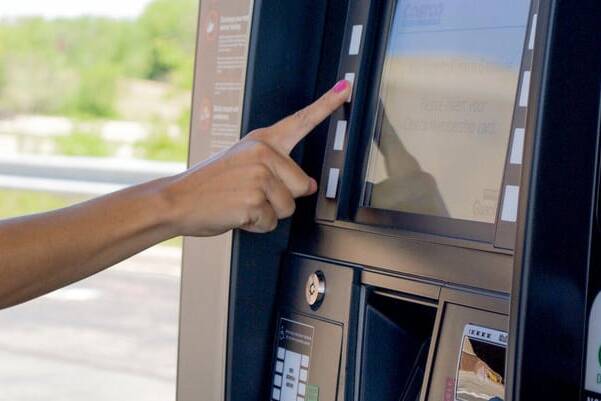 finger touching a button on the panel of a gas pump