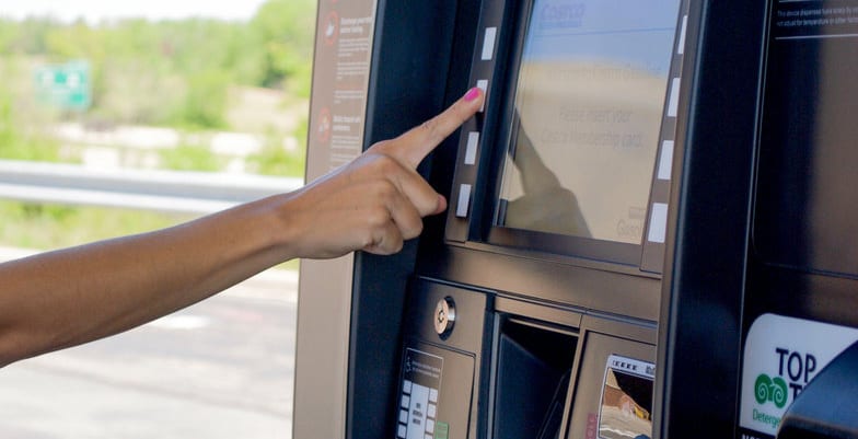 finger touching a button on the panel of a gas pump