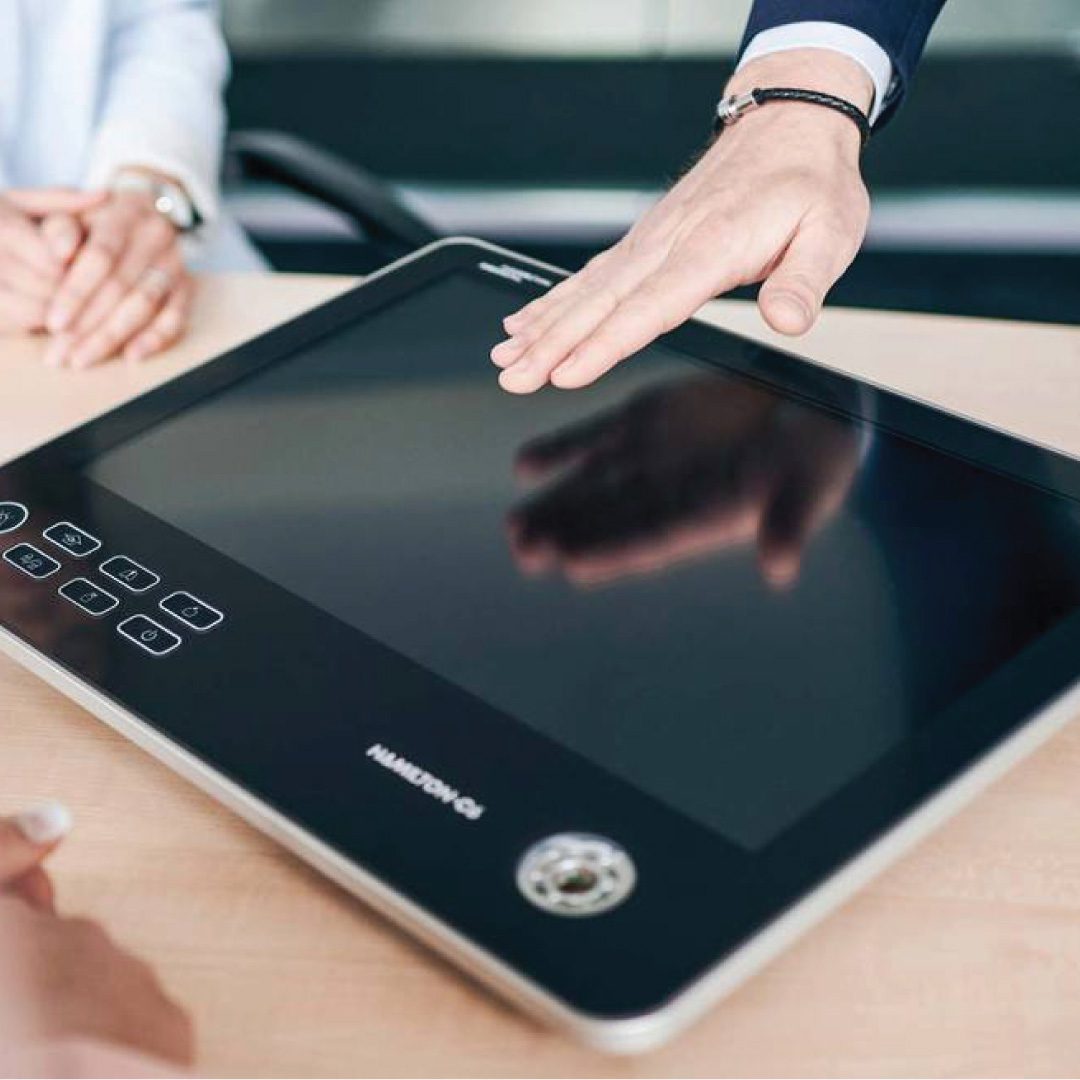 hand preparing to touch a tablet resting on a table