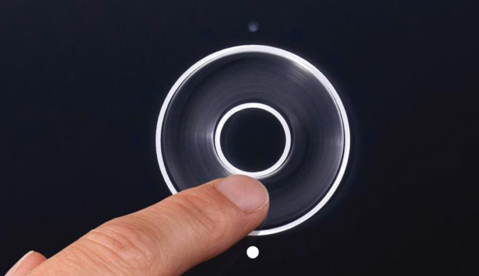 finger touching a physical dial on a black device