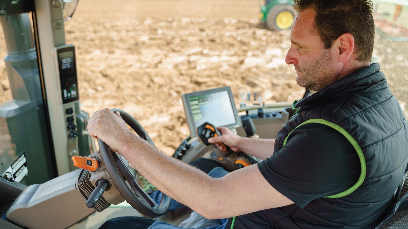 Man driving farm vehicle using a joystick