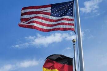 American and German flags blowing in the wind