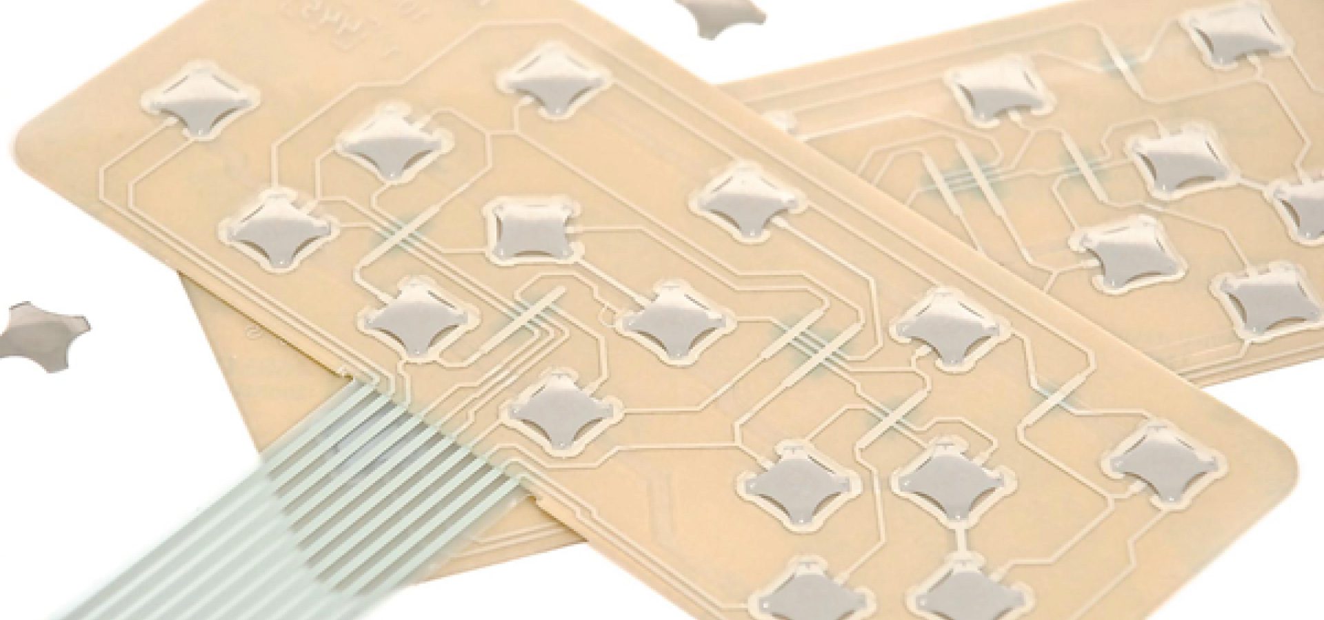 two tactile feedback circuit boards that appear peach colored