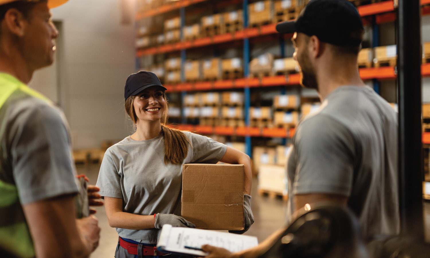 three employees having a conversation in a distribution warehouse